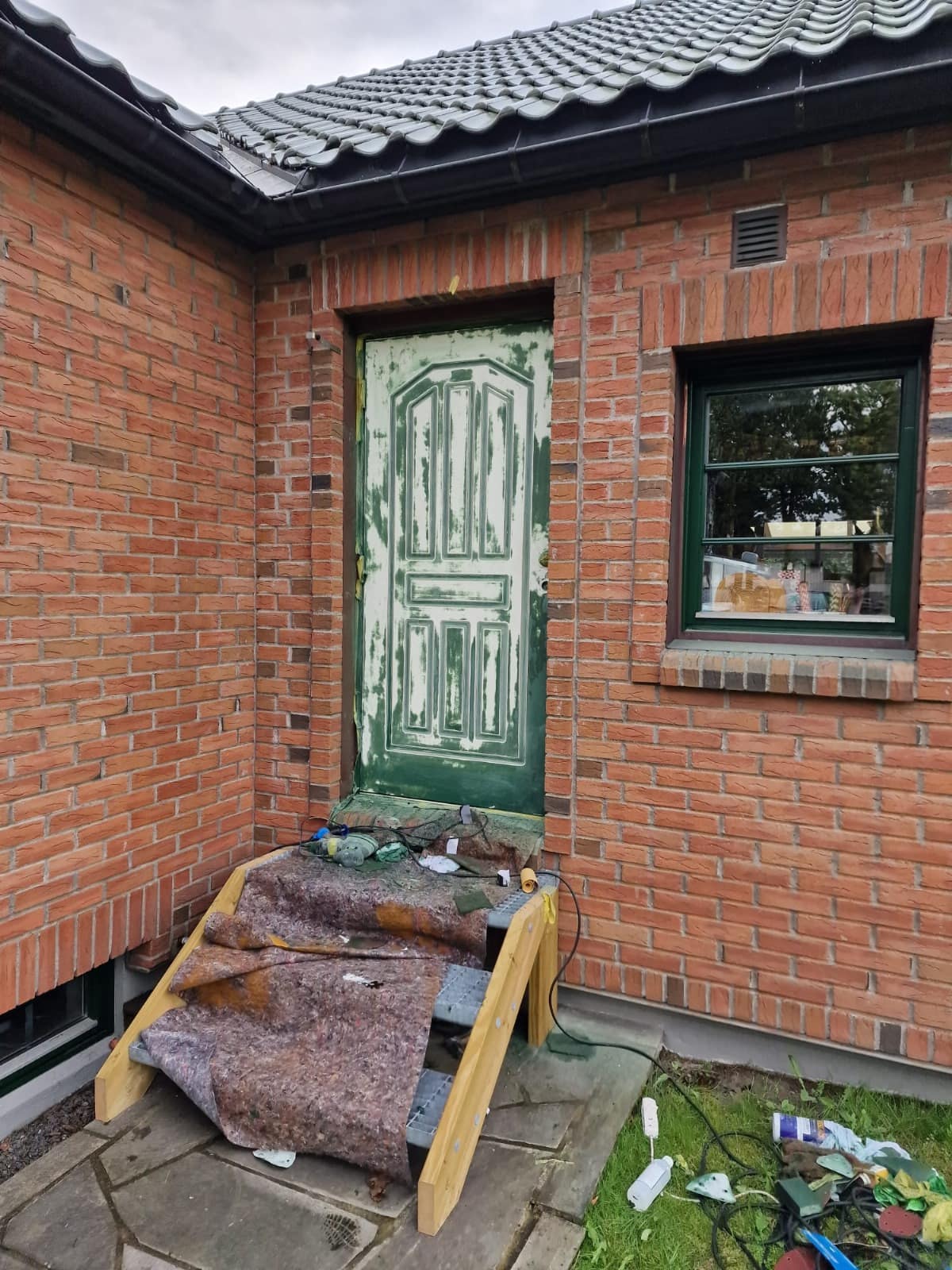 Inngangsdør på murhus under sliping og maling