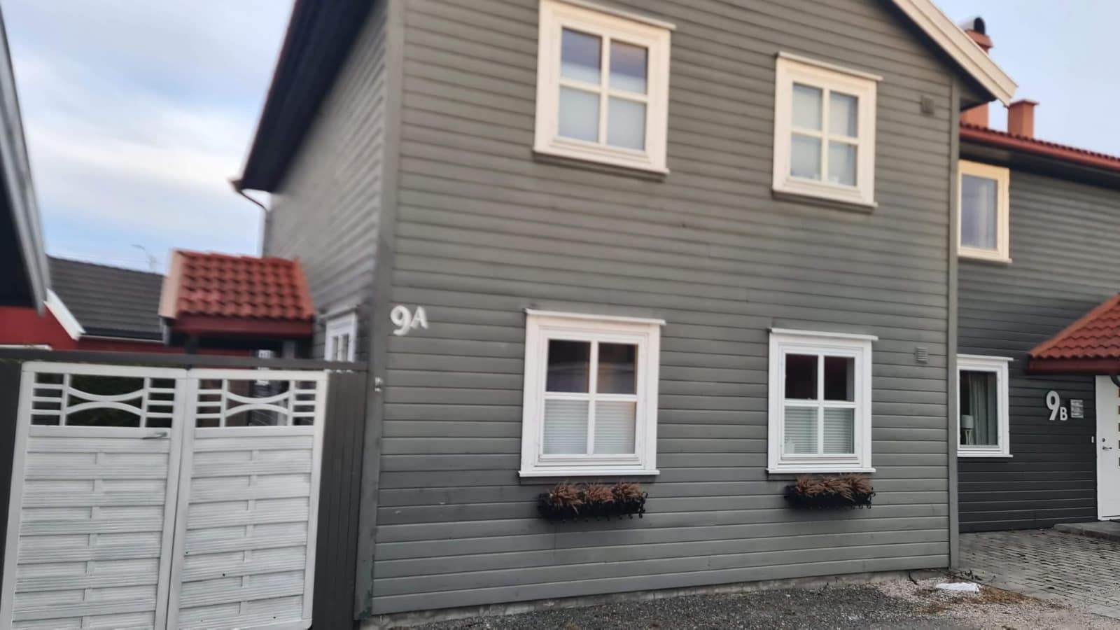 Grått tomannshus med hvite vinduer