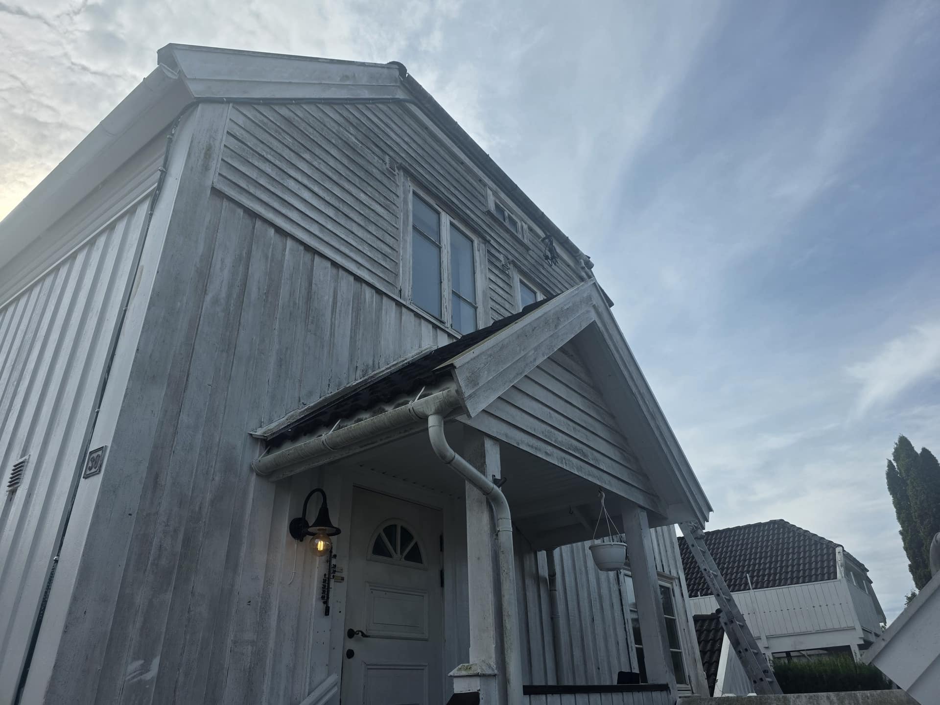 Hvitt trehus i Tønsberg sett nedenfra, klart for fasademaling