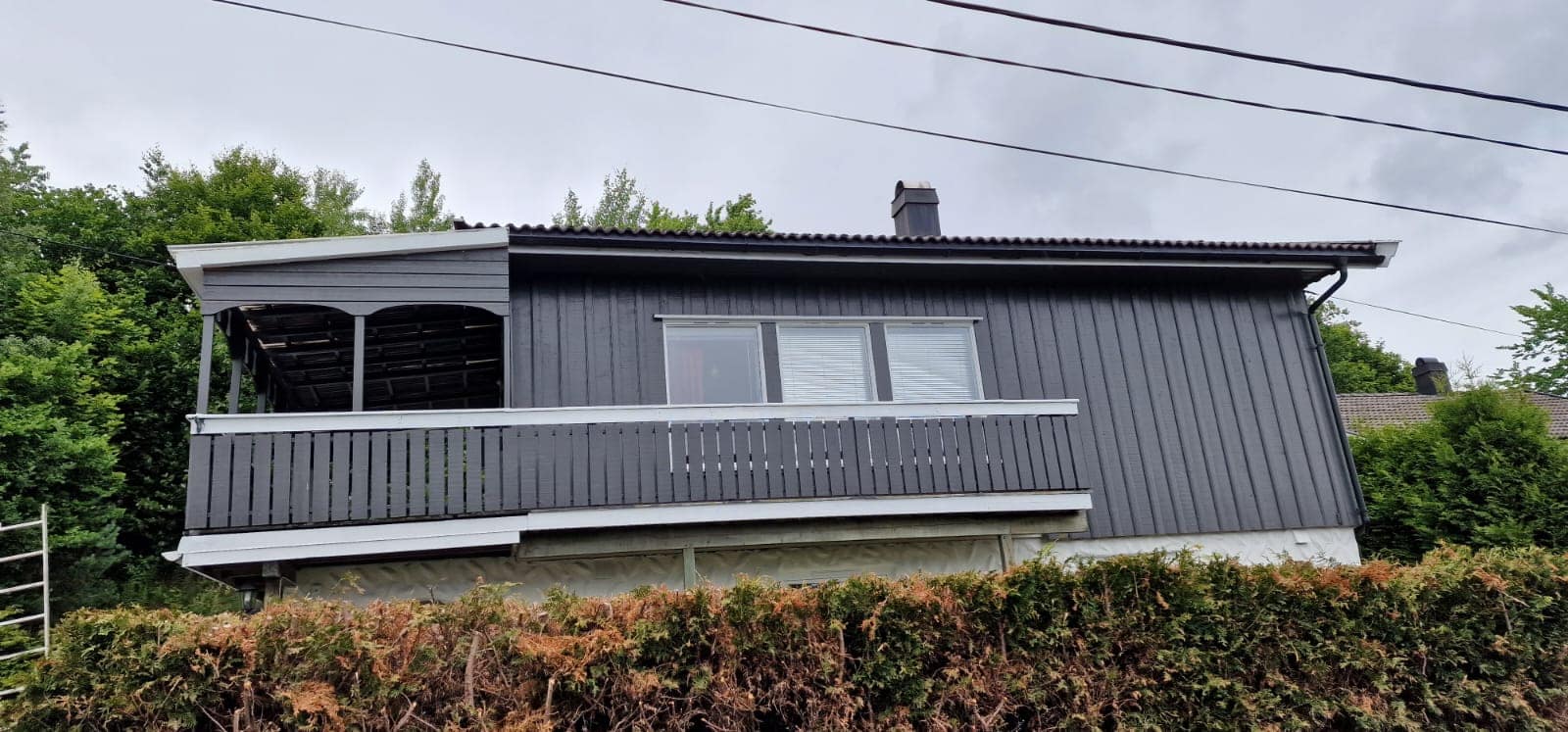 Ferdig malt mørk grå enebolig med veranda