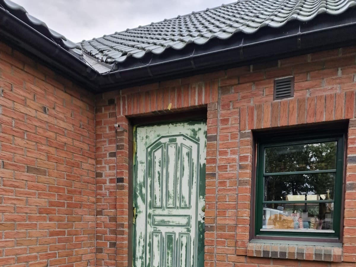 Inngangsdør på murhus under sliping og maling